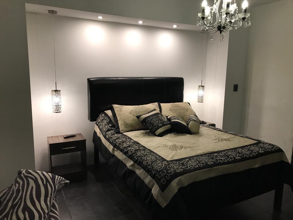 Cama matrimonial superior con detalles en madera y vista al jardín