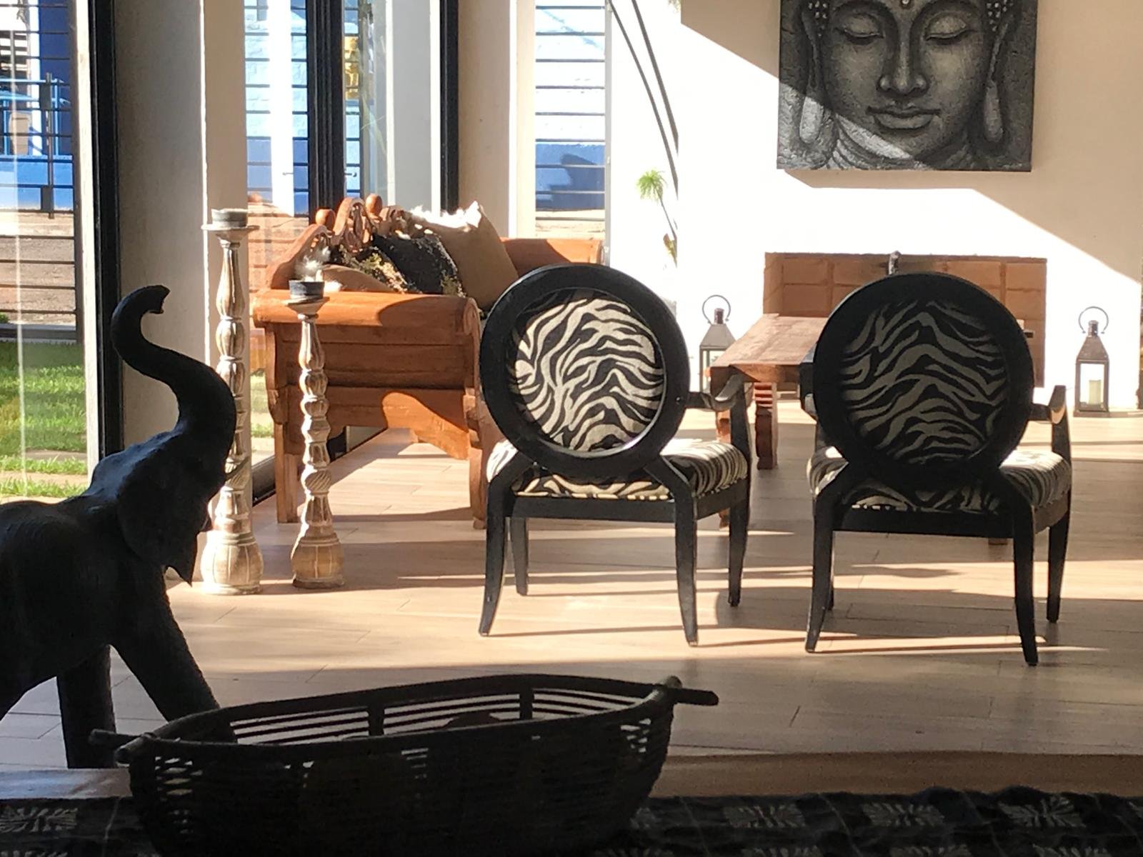 Sala de estar luminosa con elefante, estampado cebra y cuadro de Buda